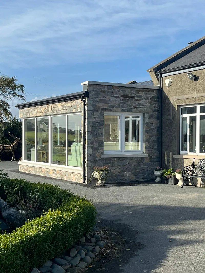 Stone faced extension with large windows