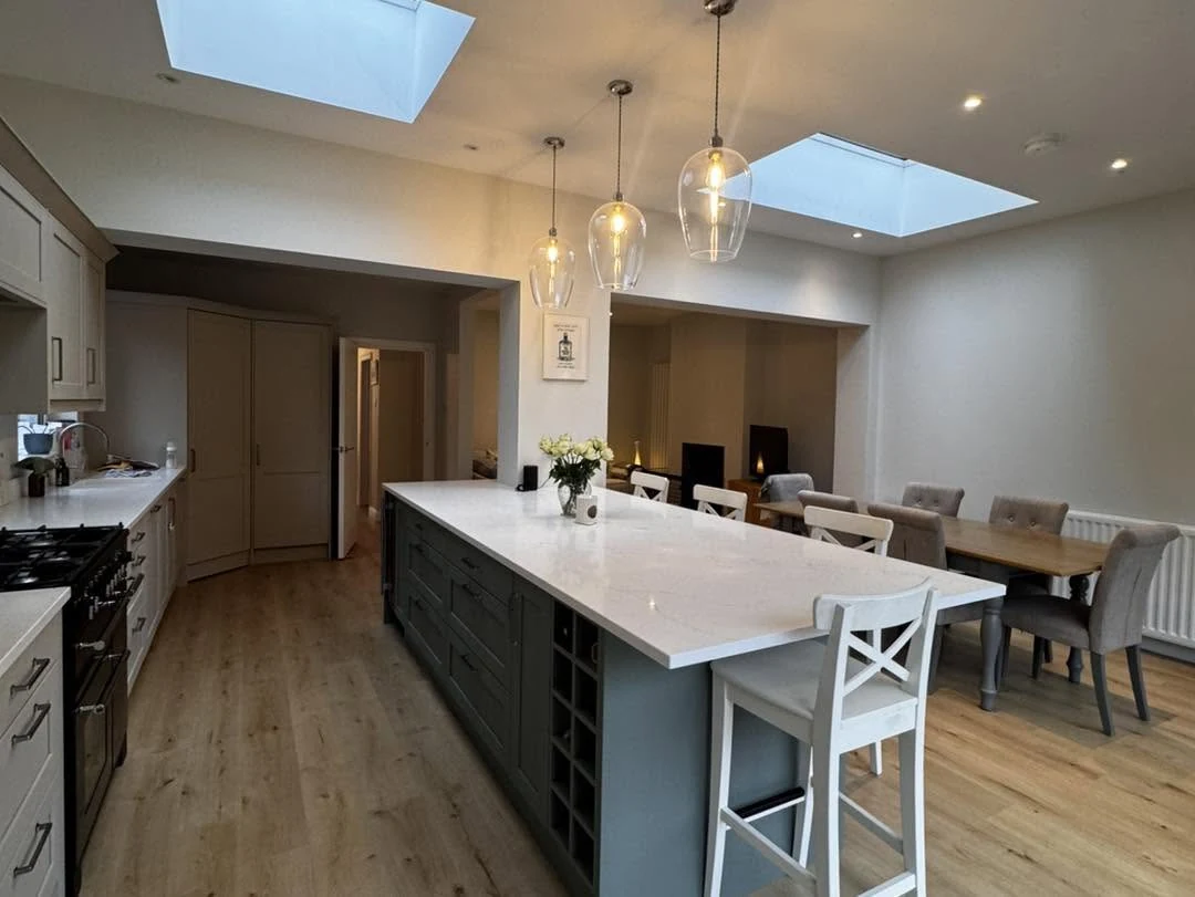Completed kitchen with a large dark island and rooflights