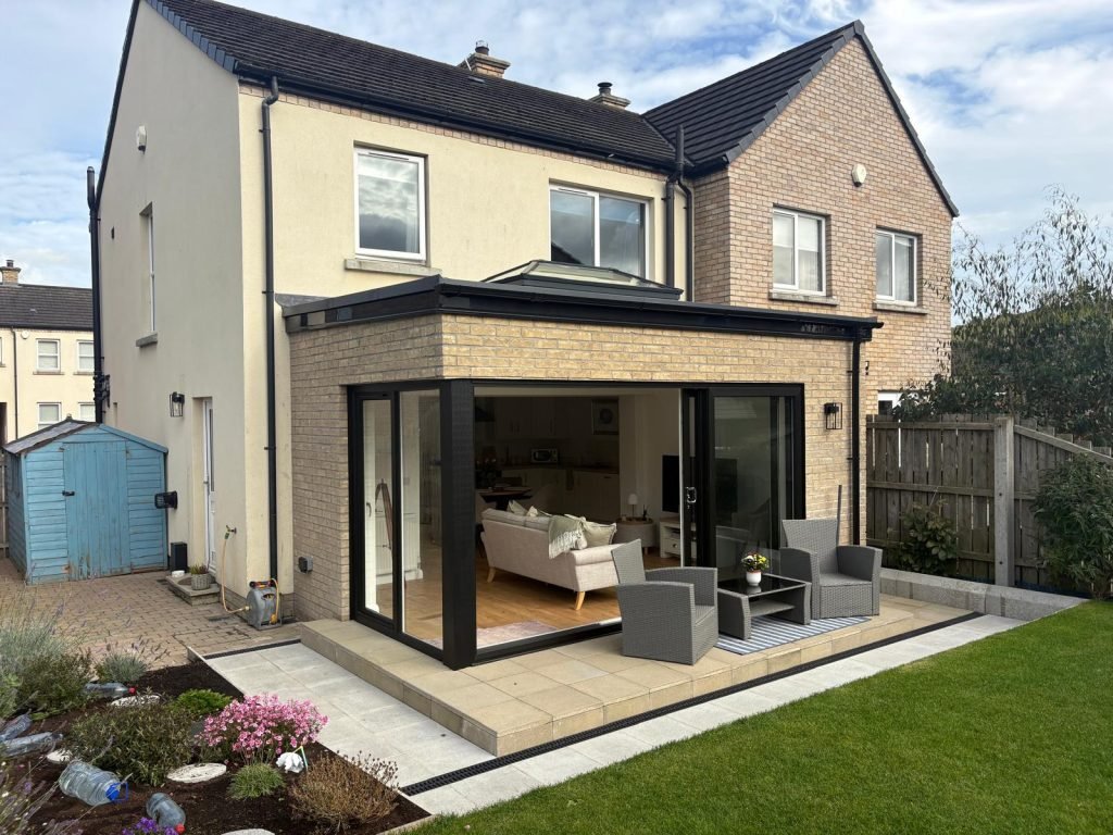 Ballynahinch sunroom with open corner glazing and a paved terrace