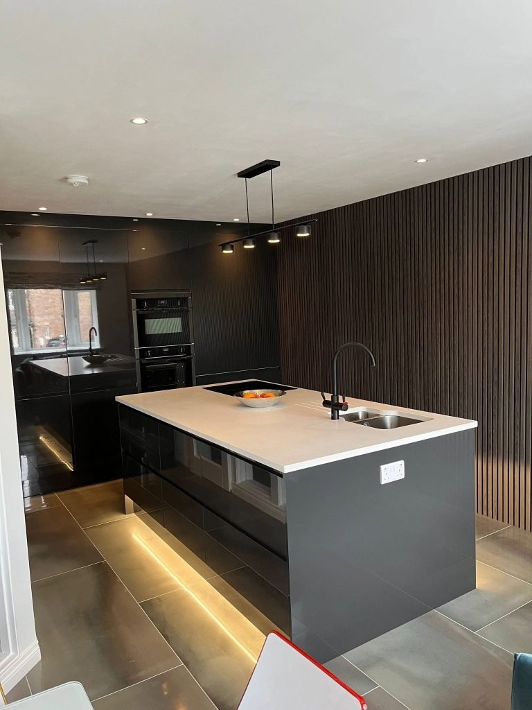 Finished grey island beside slatted wall panels and pendant lighting