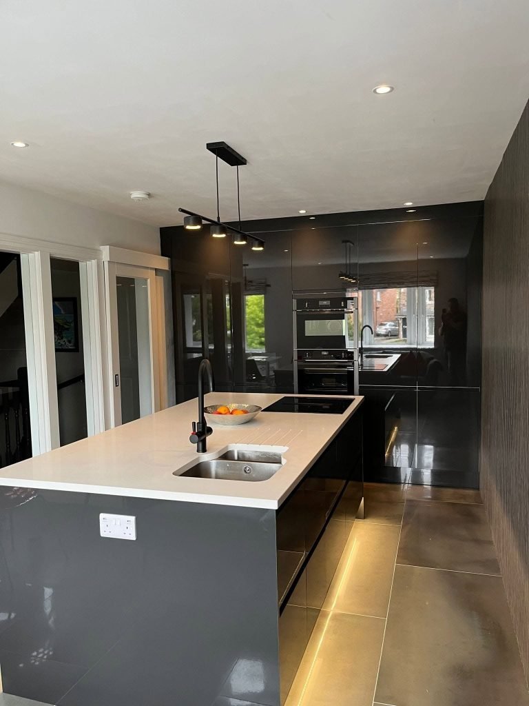 Wide view of the kitchen island between a glazed partition and slatted wall panels