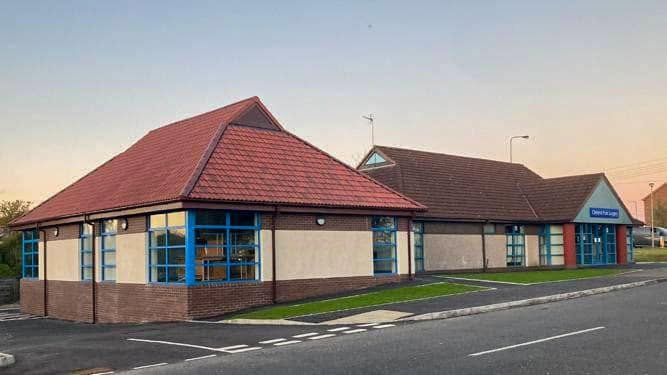 Completed surgery building with red pitched roofs and blue aluminium windows