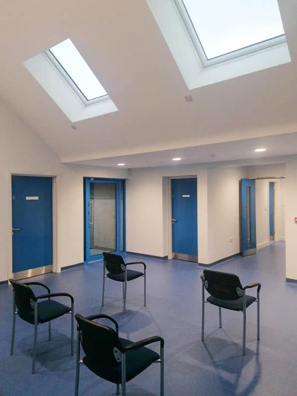 Dark chairs in a waiting area beneath two rooflights