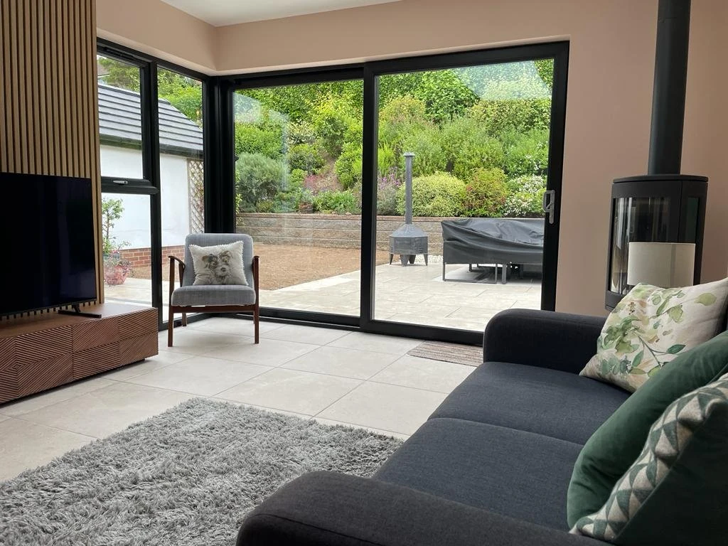 Finished sunroom with wide black framed sliding doors